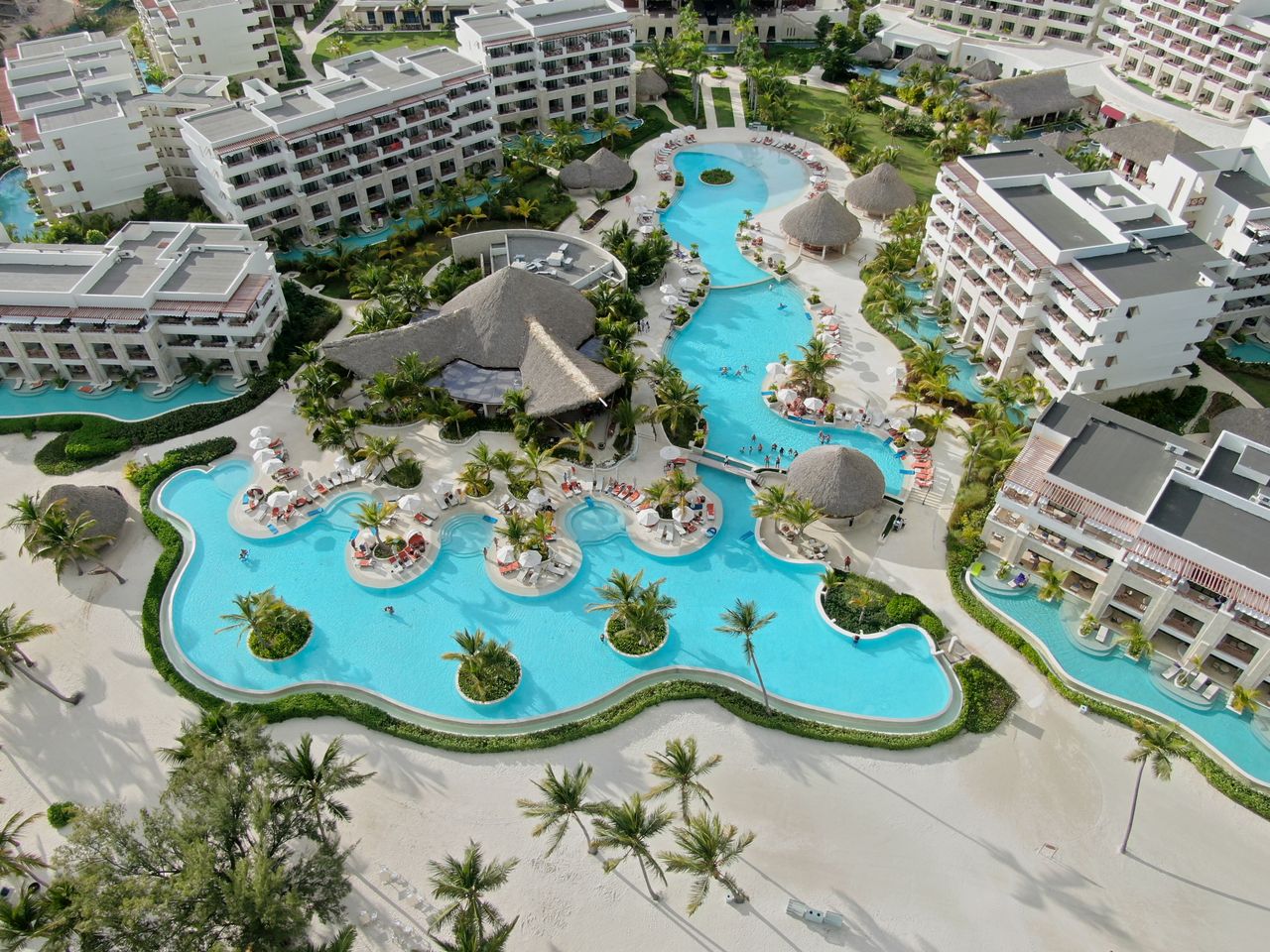 Stunning aerial shot of a tropical resort featuring large pools and palm trees.